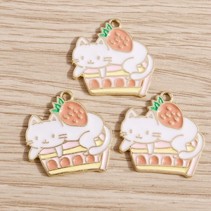 Detailed close-up of cute cat and strawberry oil-dripped alloy charms for DIY jewelry making