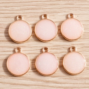 Pack of 10 geometric round alloy pendants with pink glitter inlay and rose gold frame