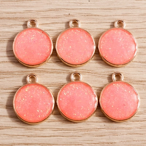 Set of 6 round geometric alloy pendants with pink glitter resin in golden metal frames