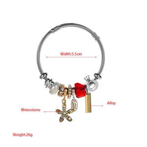 Detail of silver wire bracelet with red crystal, pearl beads, and handmade pendant charm