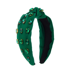 Deep green fabric knotted headband with sparkling green crystals on a white background