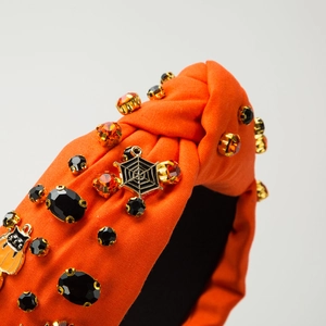 Halloween knot headband featuring orange fabric, crystals, and black cat spiderweb charms