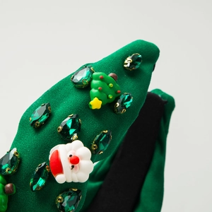 Green Christmas headband with Santa resin, mini tree, and green gemstones on light background