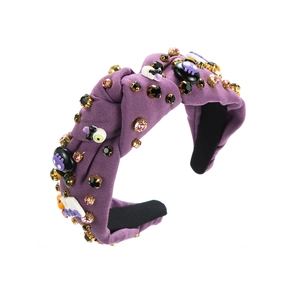 Dettaglio fascia viola di Halloween con strass scintillanti e ciondolo a forma di teschio