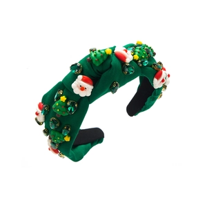 Detailed view of green Christmas headband with Santa Claus and small trees ornaments