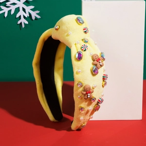 Dettaglio fascia natalizia in velluto giallo con strass, omino di pan di zenzero e caramelle