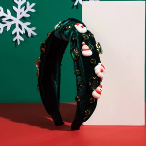 Détail du serre-tête de Noël en velours vert avec gemmes brillantes et décors de Noël