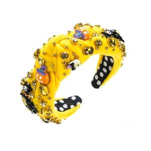 Detail of yellow velvet Halloween headband featuring pumpkins and crystal gemstone accents