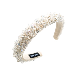 Detail of handmade beige sponge headband with shimmering glass crystals and inner label