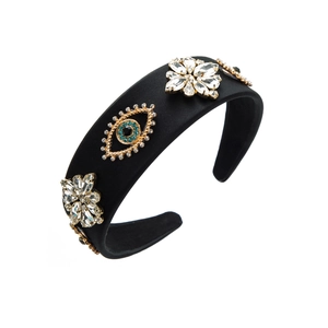 Nahaufnahme von schwarzem Samthaarreif mit Evil Eye Juwel und Strass-Blumenmuster