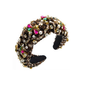 Détail d'un serre-tête en tweed avec cristaux colorés et perles sur une monture large et épaisse