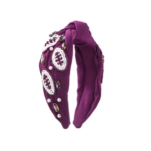 Détail d'un serre-tête violet avec perles faites main et motifs de rugby brodés