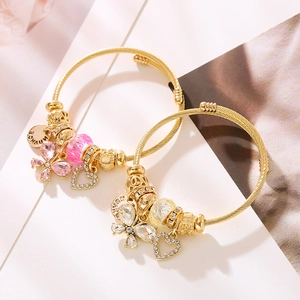 Bracciale rigido dorato regolabile con ciondoli a farfalla, cuore e perline