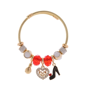 Detail of alloy charm bracelet featuring high heel, heart, and money bag pendants