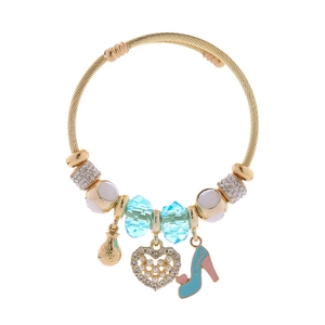 Detail of adjustable gold-woven bracelet with heart, shoe, and money bag charms