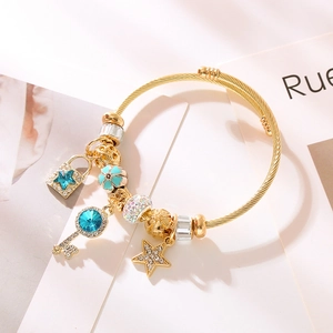 Bracciale regolabile in acciaio dorato con ciondoli a forma di stella blu e chiave