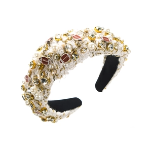 Détail d'un serre-tête en tweed blanc avec perles, strass et breloques football