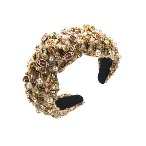 Détail d'un serre-tête en tweed avec perles, strass et breloques de football sur tissu brun