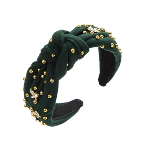 Detail eines dunkelgrünen Samt-Stirnbands mit Knotendesign, Goldperlen und Kristallschmetterlingen