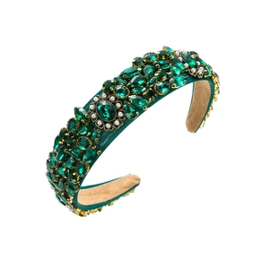 Macro detail of emerald green velvet headband with baroque rhinestones and white pearls