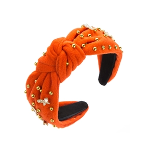 Details des orangefarbenen Samt-Haarreifens mit goldenen Perlen und Schmetterlings-Dekor