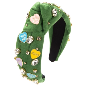 Détail d'un serre-tête en tissu vert avec breloques cœur colorées et cristaux brillants