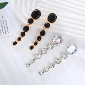 Macro detail of cascading round crystal drop earrings in gold and silver finishes