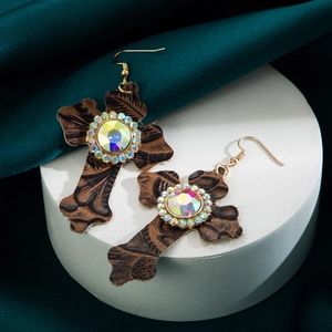 Detail van vintage bruin lederen kruis oorringen met kleurrijke kristallen strasstenen
