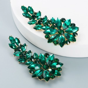 Detail of elegant gold-tone floral earrings with emerald green crystals and hollow design