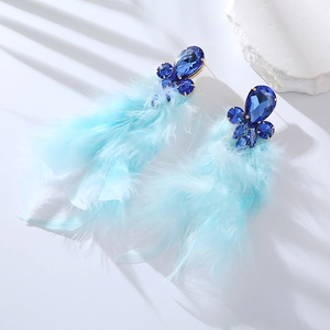 Dettaglio di orecchini lunghi con piume blu e cristalli strass blu scuro scintillanti