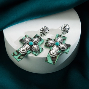Detail of cross earrings featuring turquoise stone and leopard print leather accents