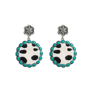 Close-up of vintage round earrings with turquoise beads and cow print leather texture