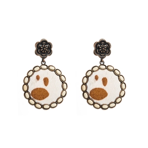 Detail of vintage round boho earrings with cow print pattern and turquoise-like beads