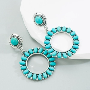 Détail de boucles d'oreilles rétro en argent avec turquoises ovales et gravure bohème