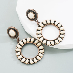 Détail de boucles d'oreilles rétro en alliage de bronze et pierres turquoise blanches