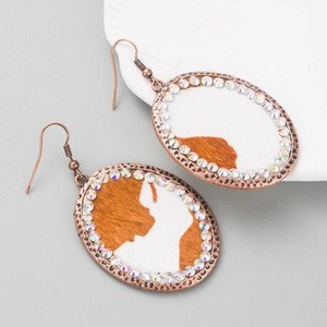 Detail of vintage copper oval earrings with cow print texture and colorful rhinestones