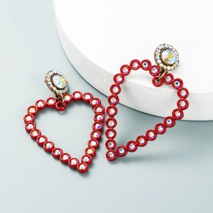 Close-up of red heart drop earrings with colorful rhinestones on a display board