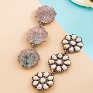Detail of vintage bohemian triple-flower drop earrings with white stone inlay