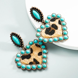 Detail van vintage hartvormige oorbellen met turquoise kralen en panterprint