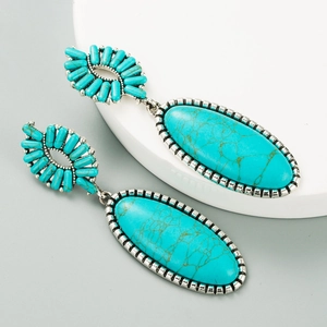 Detailed macro view of vintage silver-plated turquoise earrings with oval pendants