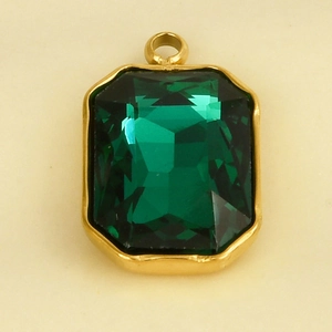 Detail van een rechthoekige smaragdgroene glazen hanger met een gepolijste 18k goudlaag