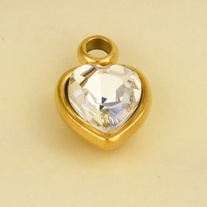 Close-up of heart-shaped gold pendant with sparkling clear crystal inlay and metal loop