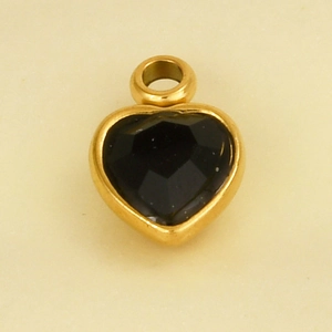 Macro view of a gold-plated heart pendant with faceted black gemstone inlay details