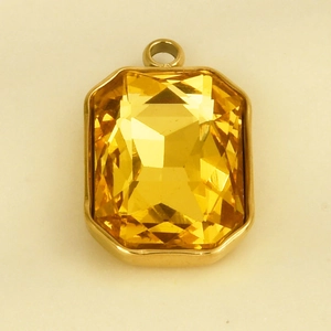 Gedetailleerde macro van een 18k vergulde rechthoekige hanger met barnsteenkleurig glas
