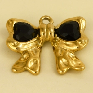 Macro-detail van een gouden strik hanger met zwarte hartvormige facetgeslepen edelstenen