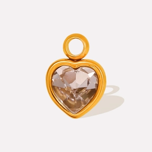 Detailed macro view of heart-shaped gold pendant with faceted clear crystal stone