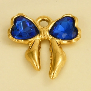 Macro detail of a golden bow pendant with two blue heart-shaped faceted glass stones
