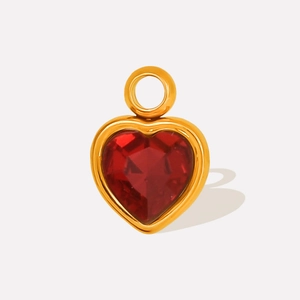 Detail of a heart-shaped gold-plated stainless steel pendant with a red faceted crystal