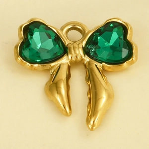Detailed view of a gold bow pendant with heart-shaped green gemstones and glass crystals