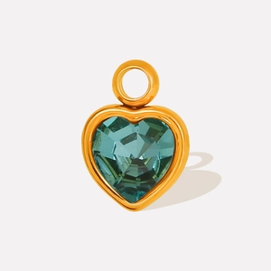 Macro shot of heart-shaped teal crystal pendant with a polished gold stainless steel frame